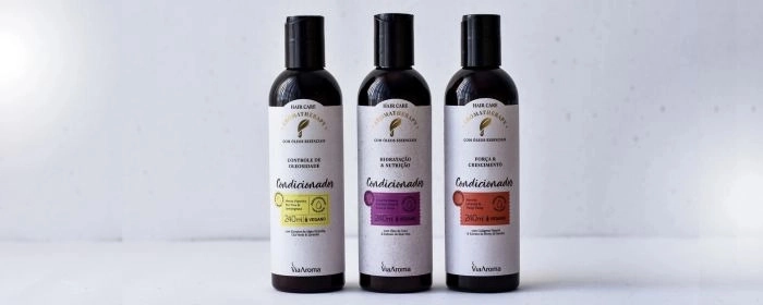 Três frascos de condicionador Via Aroma e um fundo branco